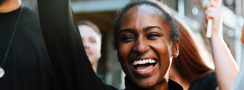 Une femme noire manifeste aux côtés de ses camarades manifestants