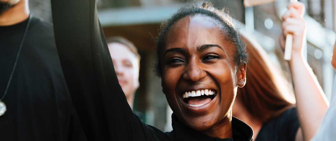 Une femme noire manifeste aux côtés de ses camarades manifestants