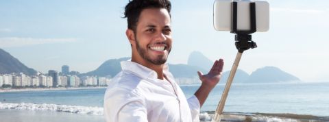 Pires technos du 21ème siècle Jeune homme à la plage, se prenant en photo avec une perche à Selfie