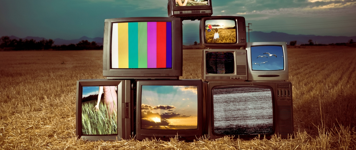 Des télévisions allumées au milieu d'un champ rasé