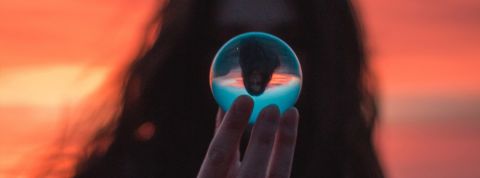 Imaginer un futur meilleur... 5 conférences à ne pas louper à Paris ! une femme tient une boule de cristal devant son visage