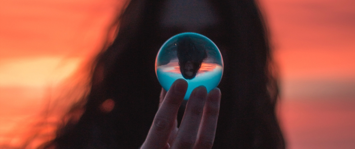 Imaginer un futur meilleur... 5 conférences à ne pas louper à Paris ! une femme tient une boule de cristal devant son visage