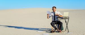 Un homme, seul, assis à un bureau dans le désert