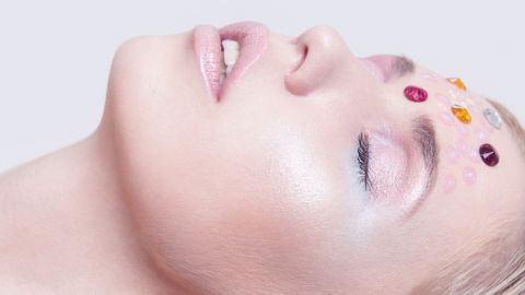 Une femme avec des cristaux sur le visage