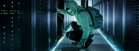 Une personne en capuche s'occupe d'un data center