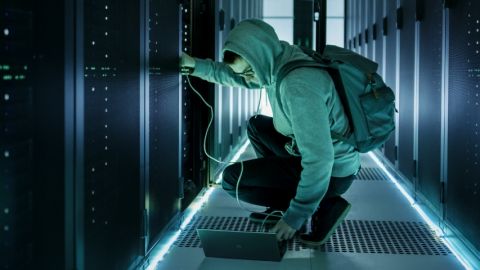 Une personne en capuche s'occupe d'un data center