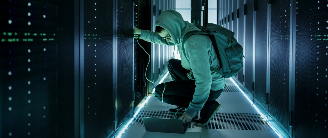 Une personne en capuche s'occupe d'un data center