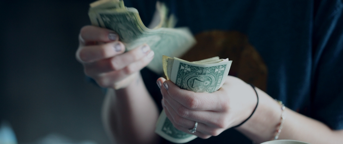 26 entreprises concernées par la taxe GAFA Une femme qui compte des billets de dollars
