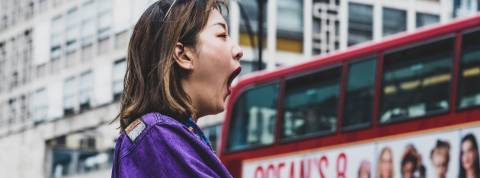 Comment la sophrologie peut aider les gens qui stressent Une femme en train de bailler devant un bus