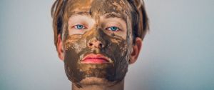 Un homme avec un masque à l'argile sur le visage