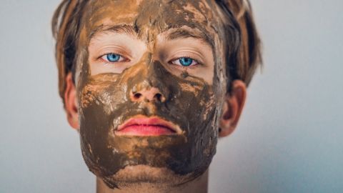Un homme avec un masque à l'argile sur le visage