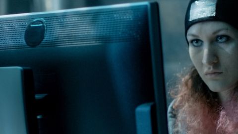 une hackeuse devant un ordinateur