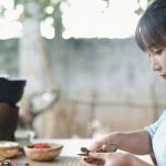 Une jeune fille fait du DIY sur une table en bois