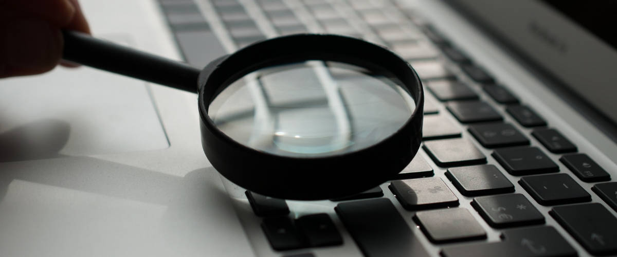 Facebook veut faire preuve de transparence Une loupe au-dessus d'un clavier d'ordinateur