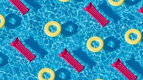 Une piscine remplie de matelas gonflables roses et de bouées jaunes