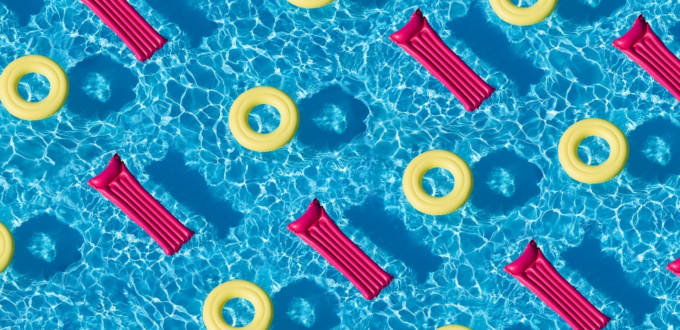 Une piscine remplie de matelas gonflables roses et de bouées jaunes