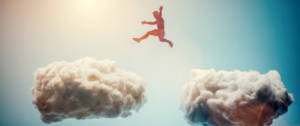 Un homme saute de nuages en nuages dans le ciel
