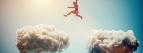 Un homme saute de nuages en nuages dans le ciel