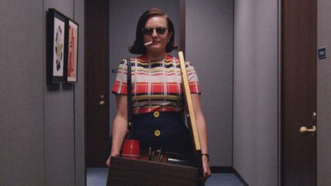 Une femme avec une cigarette part de son bureau carton à la main