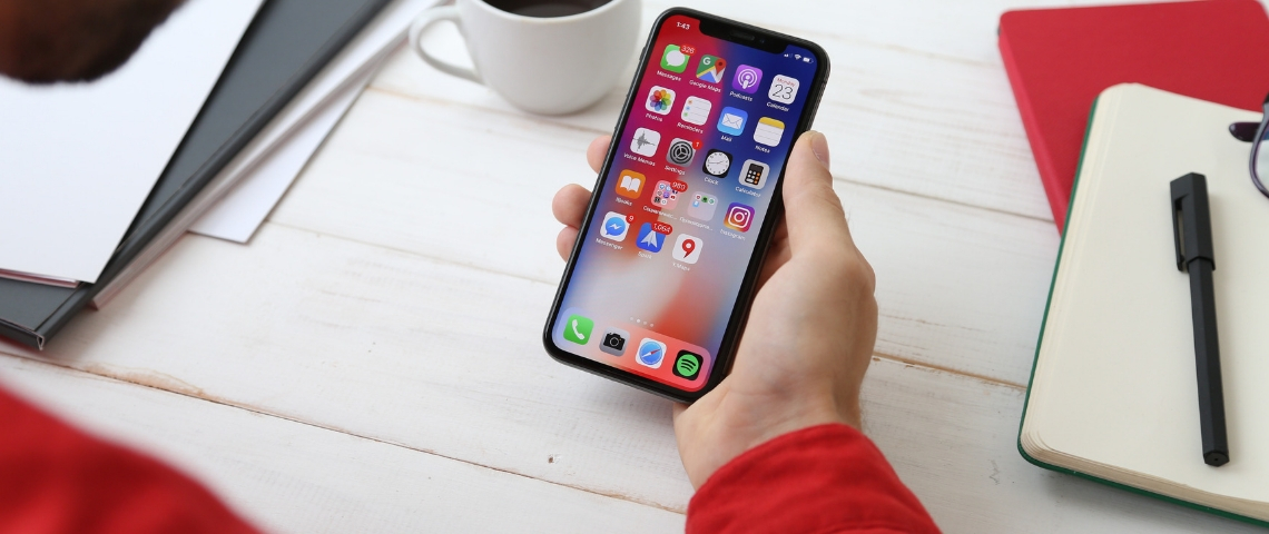 Les applications mobiles médias qui consomment le plus Une main qui tient un iPhone