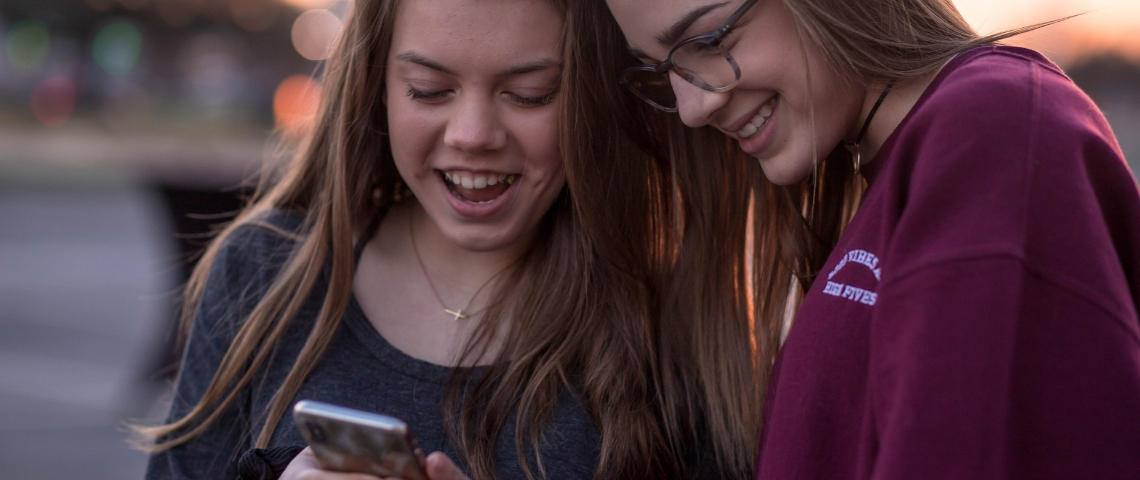 Snapchat est incapable de vérifier l'âge de ses utilisateurs Deux adolescentes qui regardent un smartphone