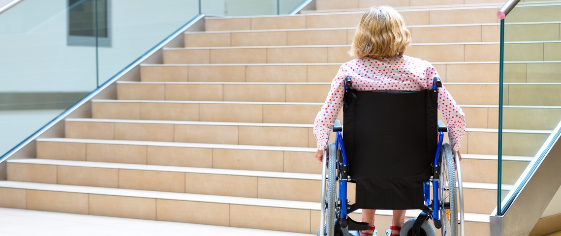 Mobilité inclusive : la France à la traîne Femme en fauteuil roulant devant des escaliers