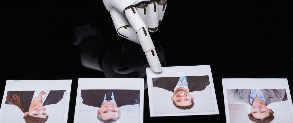 Ethique de l'intelligence artificielle Doigt robotique pointe la photo d'un homme jeune parmi quatre photos.