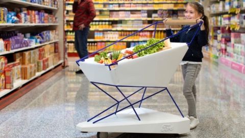 Petite fille poussant un chariot Ford dans un supermarché