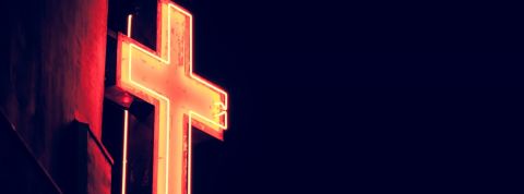 crypto-monnaie religion Néon en forme de croix chrétienne illuminé dans la nuit.