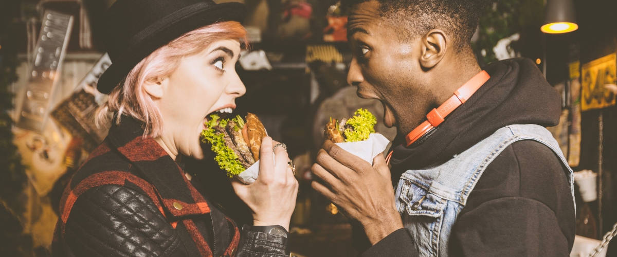 Le tour du monde des restos engagés pour l'écologie Une femme blanche et un homme noir qui mangent un burger en se regardant