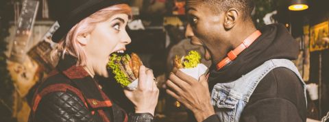 Le tour du monde des restos engagés pour l'écologie Une femme blanche et un homme noir qui mangent un burger en se regardant