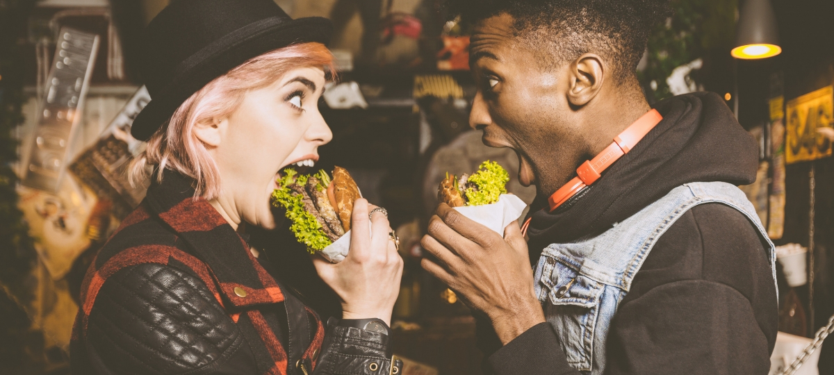 Le tour du monde des restos engagés pour l'écologie Une femme blanche et un homme noir qui mangent un burger en se regardant
