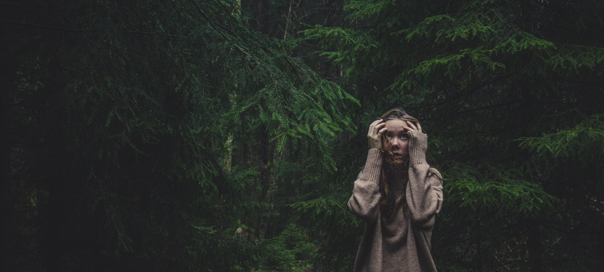Eco-anxiété : le changement climatique nous envoie chez le psy Une jeune femme qui a peur dans la forêt