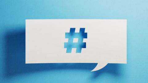 Qui sont les meilleurs dircom sur Twitter ? Un papier perforé avec un symbole de hashtag sur un fond bleu