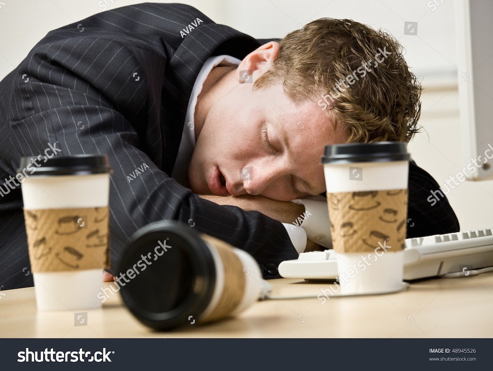 un homme dort sur son bureau
