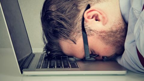 un homme dort sur son clavier au bureau
