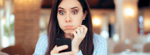 En France les jeunes font moins d'heures supplémentaires non payées que leurs aînés Une femme brune en train de s'énerver derrière son téléphone portable