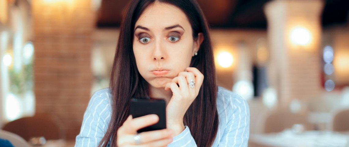 En France les jeunes font moins d'heures supplémentaires non payées que leurs aînés Une femme brune en train de s'énerver derrière son téléphone portable