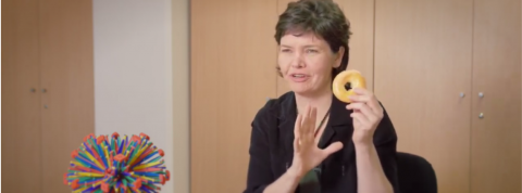 Kate Raworth nous explique la théorie du donut kate raworth en train de tenir un donut