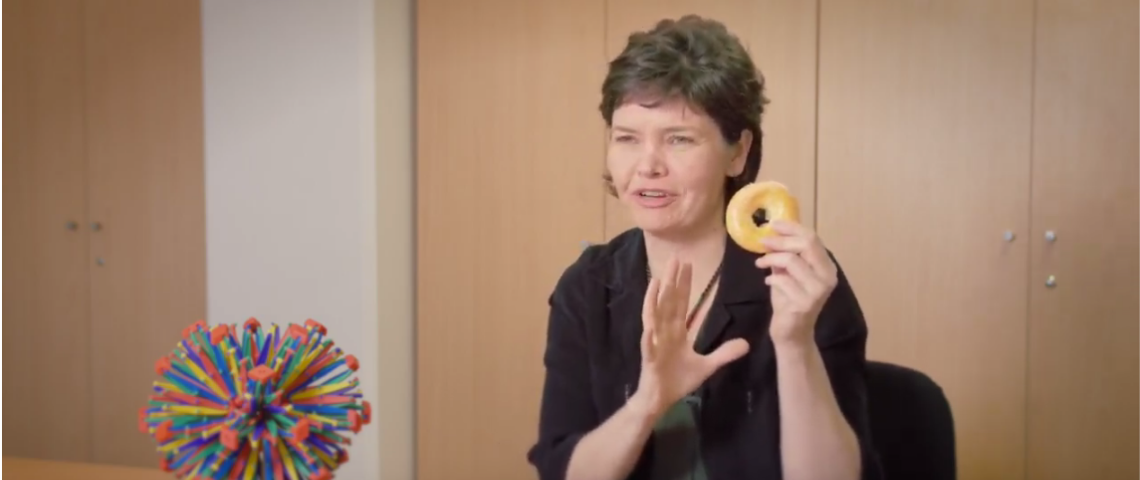 Kate Raworth nous explique la théorie du donut kate raworth en train de tenir un donut