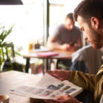 un homme lit un magazine dans un bar