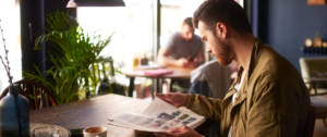 un homme lit un magazine dans un bar