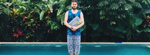 Quels sont les meilleurs avantages sociaux ? Un homme en train de tenir un ordinateur devant une piscine