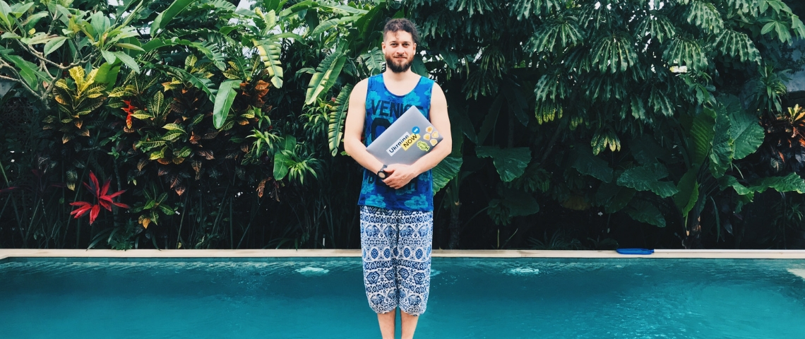 Quels sont les meilleurs avantages sociaux ? Un homme en train de tenir un ordinateur devant une piscine