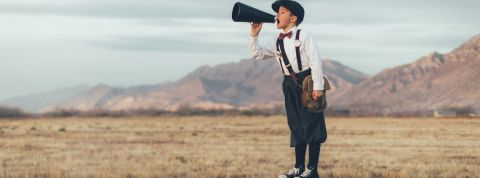 Les nouveaux médias veulent changer le monde un petit garçon dans un champ sur un tabouret qui parle dans un haut parleur