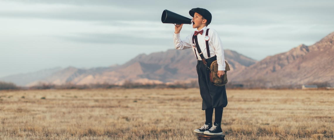 Les nouveaux médias veulent changer le monde un petit garçon dans un champ sur un tabouret qui parle dans un haut parleur