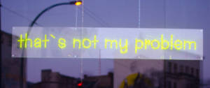 Un néon dans une vitrine qui dit "that's not my problem"