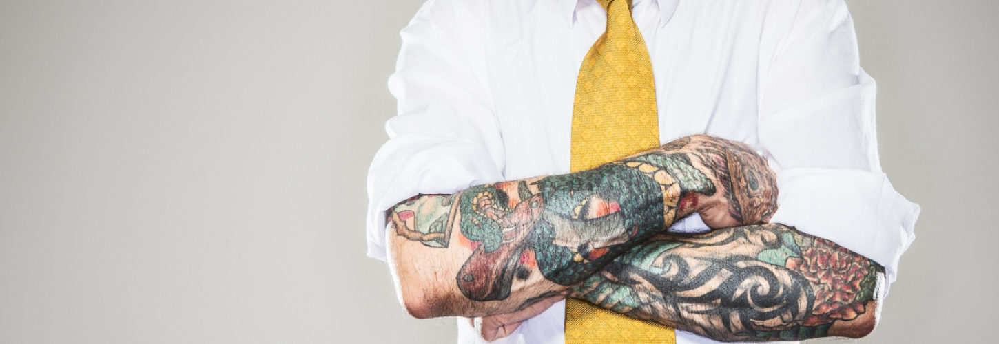 Comment réussir son personal branding Un homme avec un cravate jaune et des tatouages sur les bras