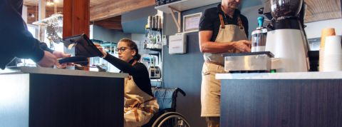 La liste des restaurants engagés en France une personne en chaise roulante en train de servir un client au comptoir au restaurant