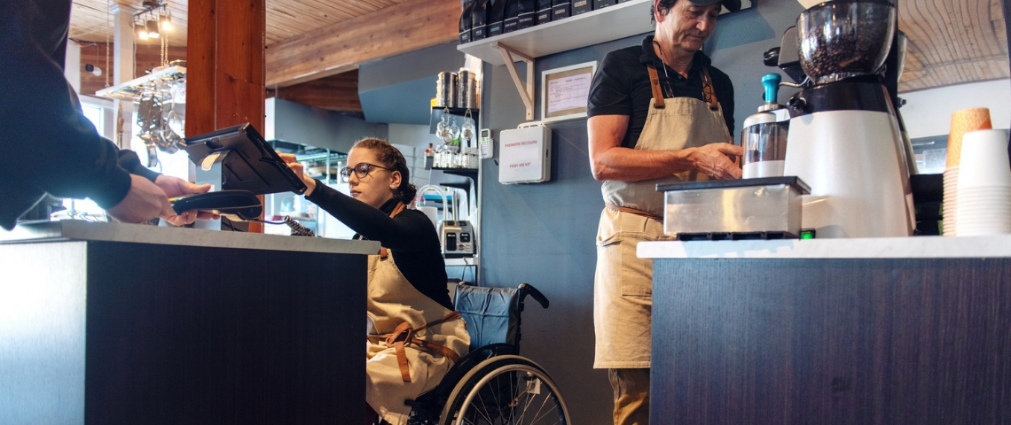 La liste des restaurants engagés en France une personne en chaise roulante en train de servir un client au comptoir au restaurant